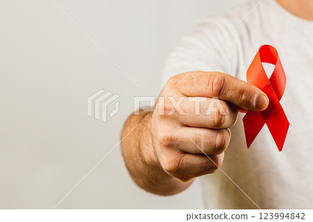 Individual holding red awareness ribbon symbolizing health advocacy efforts 123994842
