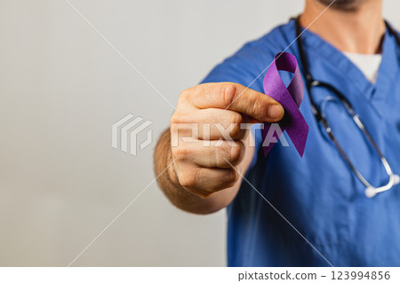 Healthcare professional advocates for awareness with purple ribbon in hand 123994856