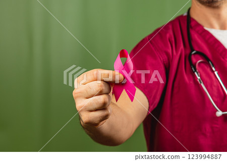 Healthcare worker promoting breast cancer awareness with pink ribbon 123994887