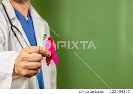 Doctor holding a pink ribbon symbolizing breast cancer awareness initiative 123994897