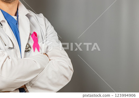 Doctor wearing pink ribbon to support breast cancer awareness campaign Doctor wearing pink ribbon to support breast cancer awareness campaign 123994906
