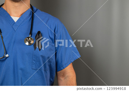 Healthcare worker wearing blue scrubs with black ribbon for mourning Healthcare worker wearing blue scrubs with black ribbon for mourning 123994918