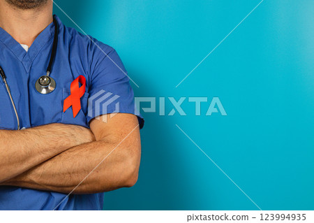 Healthcare worker promotes awareness with red ribbon on blue background 123994935