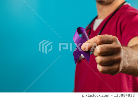 Health pro raises awareness with purple ribbon on blue backdrop 123994938