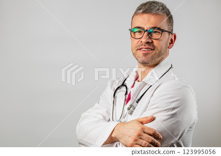 Doctor in white coat poses confidently for a professional portrait at clinic Doctor in white coat poses confidently for a professional portrait at clinic 123995056