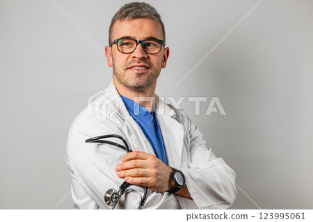 Medical professional in white coat holding stethoscope with a smile 123995061