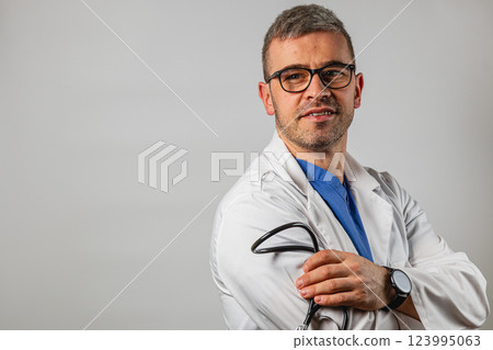 Healthcare professional in a white coat poses confidently with a stethoscope Healthcare professional in a white coat poses confidently with a stethoscope 123995063