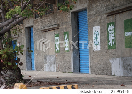 Scenery of an old warehouse building with blue shutters and Safety First written on the wall Scenery of an old warehouse building with blue shutters and Safety First written on the wall 123995496