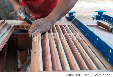 Carpenter working with equipment on wooden table, working with wooden door in new home interior industry. Carpenter working with equipment on wooden table, working with wooden door in new home interior industry. 123996437