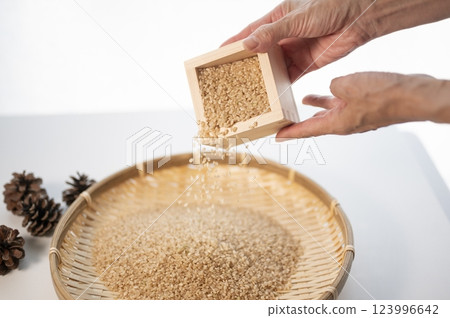 Weigh new brown rice with a wooden box Weigh new brown rice with a wooden box 123996642