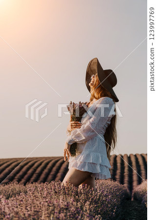 Woman in White Dress and Hat Standing in Lavender Field 123997769