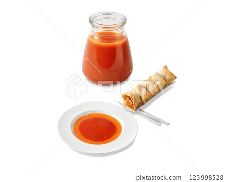 Sweet and Sour Sauce A vibrant red-orange sweet and sour sauce in a transparent jar, with a portion served 123998528