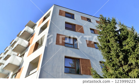 Apartment building with  symmetrical modern architecture in the city. Modern apartment building on a sunny day. Facade of a modern apartment building. Bottom view.  123999225