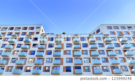 Apartment building with  symmetrical modern architecture in the city. Modern apartment building on a sunny day. Facade of a modern apartment building. Bottom view.  123999246