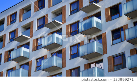 Apartment building with  symmetrical modern architecture in the city. Modern apartment building on a sunny day. Facade of a modern apartment building. Bottom view.  123999271