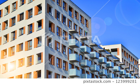 Apartment building with symmetrical modern architecture in the city. Modern apartment building on a sunny day. Facade of a modern apartment building. Bottom view. Apartment building with symmetrical modern architecture in the city. Modern apartment building on a sunny day. Facade of a modern apartment building. Bottom view. 123999281