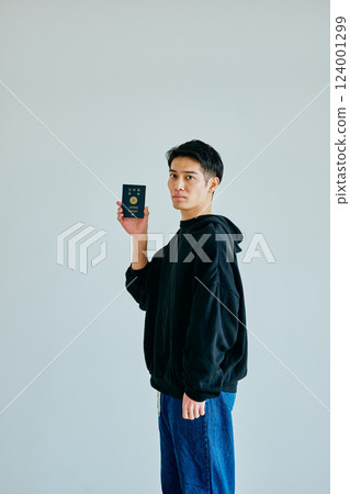 一名二十多歲的年輕人拿著護照 124001299
