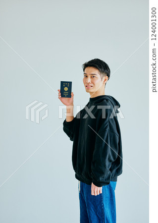 一名二十多歲的年輕人拿著護照 一名二十多歲的年輕人拿著護照 124001300