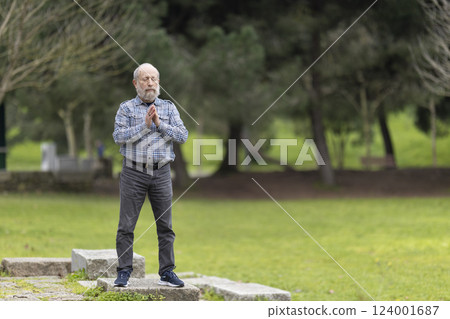 Senior man meditating in park, enjoying peaceful retirement and healthy lifestyle Senior man meditating in park, enjoying peaceful retirement and healthy lifestyle 124001687