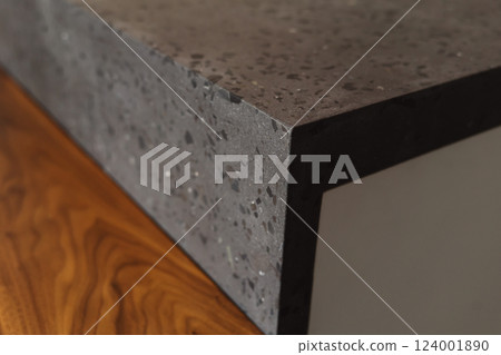 Closeup shot of adjoining between walnut table and concrete countertop 124001890