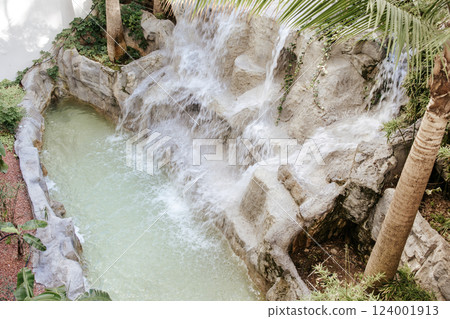 Artificial waterfall. Artistic blur of water, long exposure. Decorations decorative waterfall on the hotel grounds. 124001913