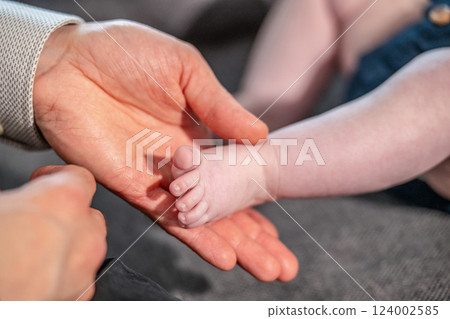 Baby feet in mother hands. Mom and her Child. Happy Family concept. Beautiful conceptual image of Maternity Baby feet in mother hands. Mom and her Child. Happy Family concept. Beautiful conceptual image of Maternity 124002585