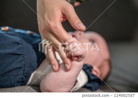 sweet tiny new born baby hand hold mum index finger. concept relationship between mother or parants and baby 124002587