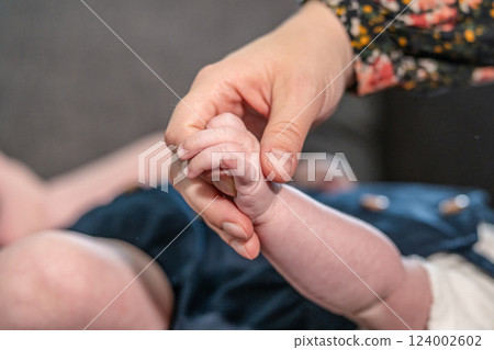 sweet tiny new born baby hand hold mum index finger. concept relationship between mother or parants and baby 124002602