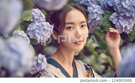 A young woman wearing a kimono with hydrangeas. A portrait of a woman buried in hydrangea flowers 124003000