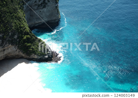 Beautiful landscape aerial view of cave of cliff rocky at the sea with foam waves and splash water of Kelingking beach and ocean of Bali, Indonesia 124003149