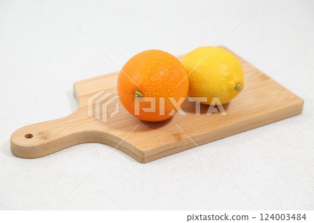 Oranges and lemons on a cutting board Oranges and lemons on a cutting board 124003484
