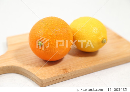 Lemons and oranges served in a wooden bowl Lemons and oranges served in a wooden bowl 124003485