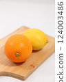 Lemons and oranges served in a wooden bowl 124003486