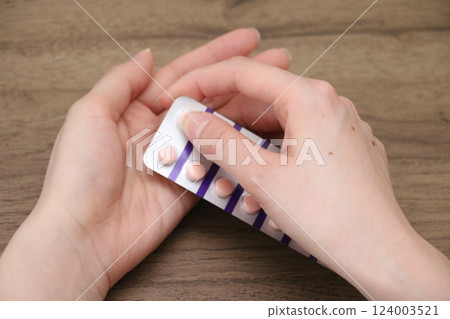 一名婦女的手正準備吃藥 一名婦女的手正準備吃藥 124003521