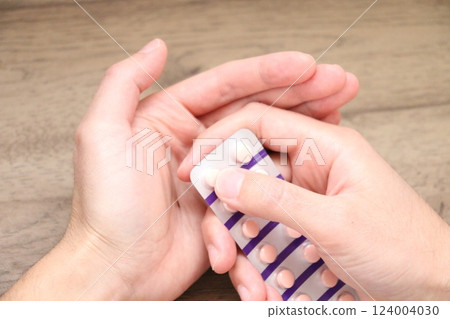 一名 30 多歲男子的手正準備服用口服藥物 124004030