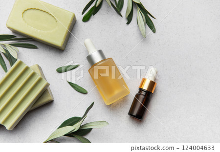 Natural soap, essential oil and olive branches creating relaxing atmosphere Natural soap, essential oil and olive branches creating relaxing atmosphere 124004633