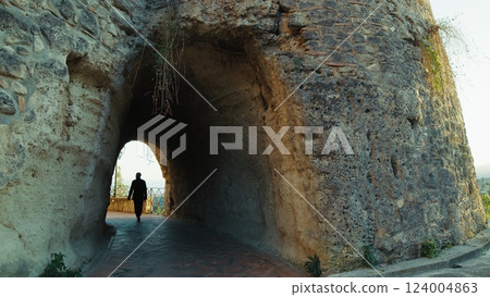 Elderly Man Tourist Observes The Tunnel Inside An Ancient Defensive Castle Elderly Man Tourist Observes The Tunnel Inside An Ancient Defensive Castle 124004863