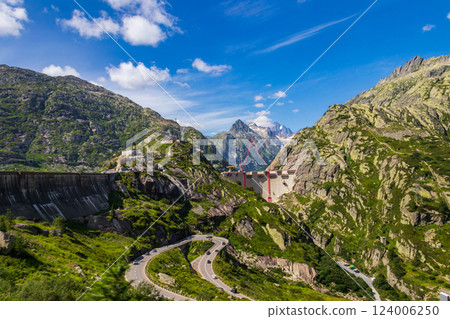 Scenic view of construction site with red cranes of new dam at Swiss mountain pass Grimsel Scenic view of construction site with red cranes of new dam at Swiss mountain pass Grimsel 124006250
