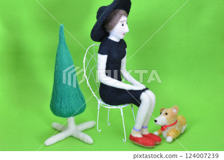 一個戴著帽子坐在椅子上的女娃娃 一個戴著帽子坐在椅子上的女娃娃 124007239