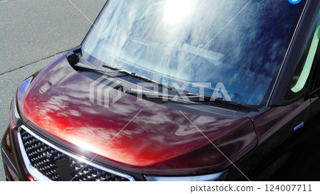 Sky reflected on the hood of a red car Sky reflected on the hood of a red car 124007711
