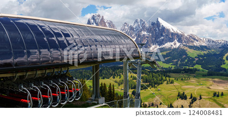 Majestic mountain landscape with ski lift and snow-capped peaks in summer near Valley of Funes at Dolomites, Italy Majestic mountain landscape with ski lift and snow-capped peaks in summer near Valley of Funes at Dolomites, Italy 124008481