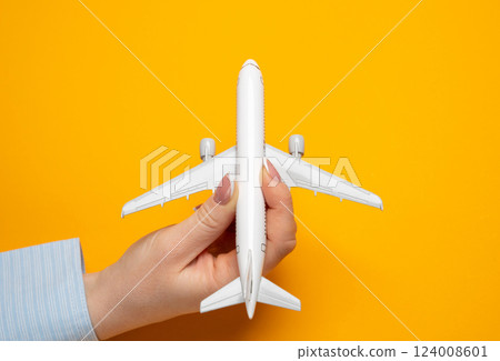 A woman launches a miniature passenger plane for takeoff. Concept of the beginning of a journey. Setting ambitious travel goals. Launch of new life experiences. A woman launches a miniature passenger plane for takeoff. Concept of the beginning of a journey. Setting ambitious travel goals. Launch of new life experiences. 124008601