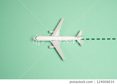 A miniature airplane flies leaving a dotted line. Air travel routes, flight paths, and global connectivity. Tourism trends, travel planning, aviation navigation. A miniature airplane flies leaving a dotted line. Air travel routes, flight paths, and global connectivity. Tourism trends, travel planning, aviation navigation. 124008614