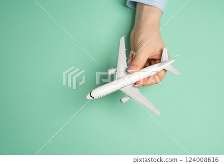 Passenger plane in hand. Air travel. Vacation planning, global mobility. Tourism, business trips, and exploring new destinations. 124008616