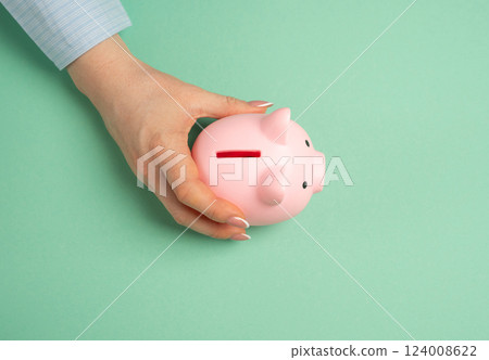 Woman playing with piggy bank. Concept of savings and pocket money. Learning financial responsibility. Family budgeting, teaching kids about savings 124008622