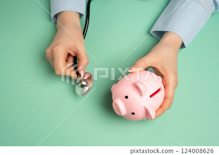 Medical examination of a piggy bank with a stethoscope. Concept of savings and financial health. Solvency and creditworthiness. Financial checkups. Personal finances effectively. Assessing savings 124008626