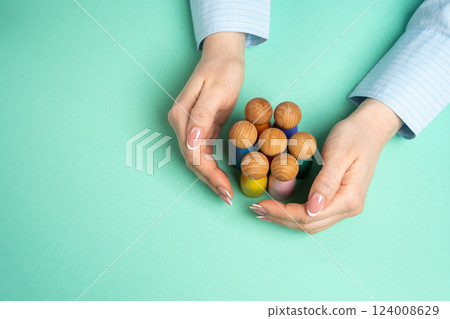 Hands protect a group of human figures. Social protection concept. Community support, and safeguarding vulnerable groups. Care, security, and social responsibility. 124008629