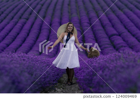 A woman is standing in a field of purple flowers 124009469