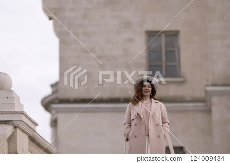 woman in elegant coat and hat against an intricate architectural backdrop, harmoniously blending modern fashion with historical allure. The soft daylight adds to its timeless appeal. woman in elegant coat and hat against an intricate architectural backdrop, harmoniously blending modern fashion with historical allure. The soft daylight adds to its timeless appeal. 124009484