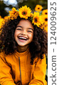 Joyful girl wearing sunflower crown smiles brightly amidst a vibrant field of sunflowers on a sunny day 124009625